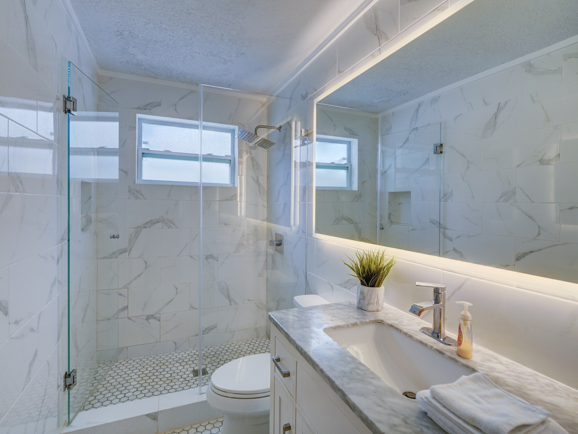 Marble bathroom with backlit mirror
